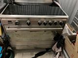 une photo d'une cuisine avec une cuisinière et quelques cartons