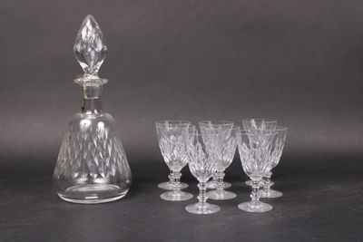four wine glasses and a decanter on a table