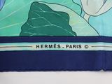 a close up of a blue and green scarf with flowers on it