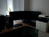 a desk with two computer monitors and a printer on it