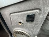 un trou dans la portière d'une voiture dans laquelle se trouve un téléphone portable