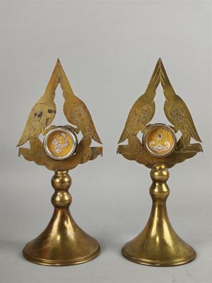 deux oiseaux dorés posés sur une horloge dorée