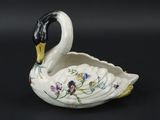 un cygne blanc à la tête noire et au bec jaune