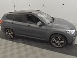 the bmw x1 is parked in a garage with a checkered floor