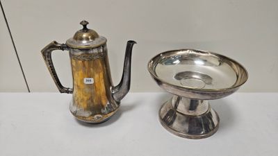 une théière en argent et une tasse en argent posées sur une table