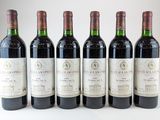 six bouteilles de vin sont alignées sur une table