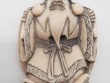 une vieille figurine sculptée représentant un homme barbu