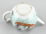 a tea pot with a handle and a lid on a table