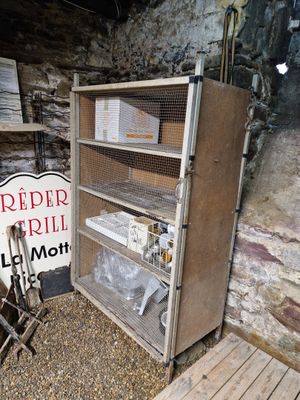 un réfrigérateur et une pancarte dans une pièce aux murs en pierre