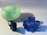 a green cup and a blue glass on a white table