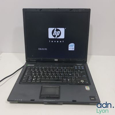 un ordinateur portable HP avec un clavier noir et une souris, posé sur une table blanche