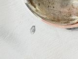 a silver bowl with a spoon in it sitting on a table