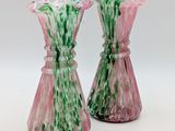 pair of pink and green glass vases on a white surface