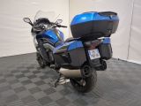 a blue motorcycle parked in a room with a checkered floor