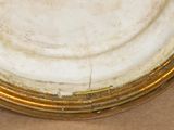 a white plate with a gold rim sitting on a table