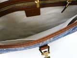 the inside of a blue and white purse with a gold zipper