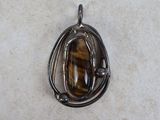 tiger ' s eye pendant on a white background