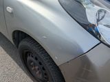a car that has been dented and is parked on the side of the road