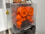 une machine remplie d'oranges, posée sur un comptoir