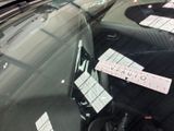 a sticker on the windshield of a car that is parked in a parking lot