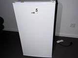 a small white refrigerator in the corner of a room