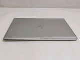 the back of a laptop computer sitting on top of a white table