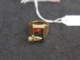 une bague en or sertie d'une pierre rouge et verte