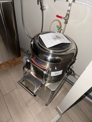 a stainless steel kettle sitting in a kitchen next to a refrigerator