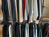 a lot of clothes hanging on a rack in a store