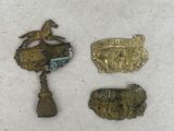 three small metal badges sitting next to each other on a white surface