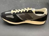 black and grey sneakers with white laces on a black surface