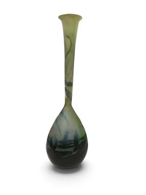 un vase vert et noir posé sur une surface blanche