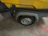 a close up of a yellow truck with a black bag on the back of it