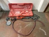 a tool in a case sitting on the floor next to a hose