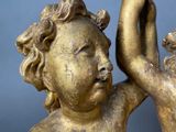 a gold statue of a child holding a bird