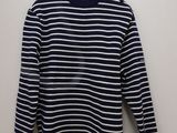 a black and white striped sweater hanging on a hanger