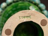 a close up of a green vase with a hole in it