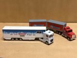 trois camions miniatures posés les uns à côté des autres sur une table