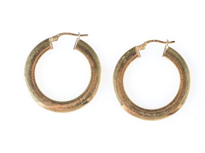 une paire de boucles d'oreilles en or sur fond blanc