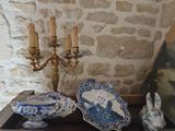 Plusieurs assiettes bleues et blanches ainsi qu'un lustre sont posés sur une table.