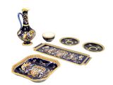 a blue and gold table setting with a vase, plates, and trays