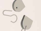 two gray hooks on a white surface with a white background