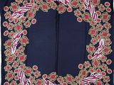 a close up of a blue scarf with red flowers on it