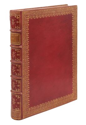 un vieux livre à la couverture rouge et à la bordure dorée