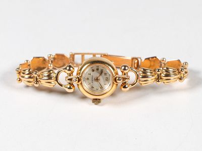 une photo d'une montre-bracelet pour femme posée sur une surface blanche