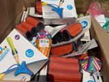 une boîte en carton remplie de fournitures scolaires et une paire de ciseaux