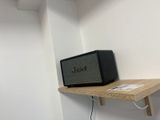 a small wooden shelf with a speaker on top of it