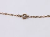 a close up of a gold chain with a heart on it