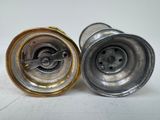 two silver and gold salt and pepper shakers on a white surface