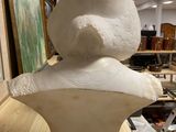 a sculpture of a man sitting on top of a white bust